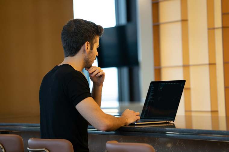 A hotel manager consults the screen of their property management system displaying reservations and availability.