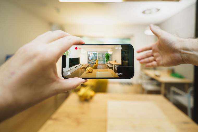 Ein Gastgeber, der sein Mietangebot mit einem Smartphone filmt, um Social-Media-Inhalte zu erstellen.