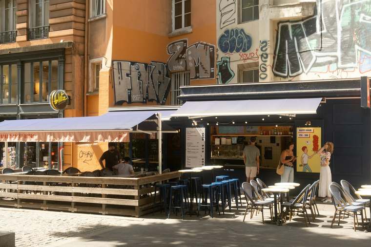 Una terrazza di caffè francese con vista su un paesaggio emblematico, simboleggiando il fascino duraturo del turismo in Francia.