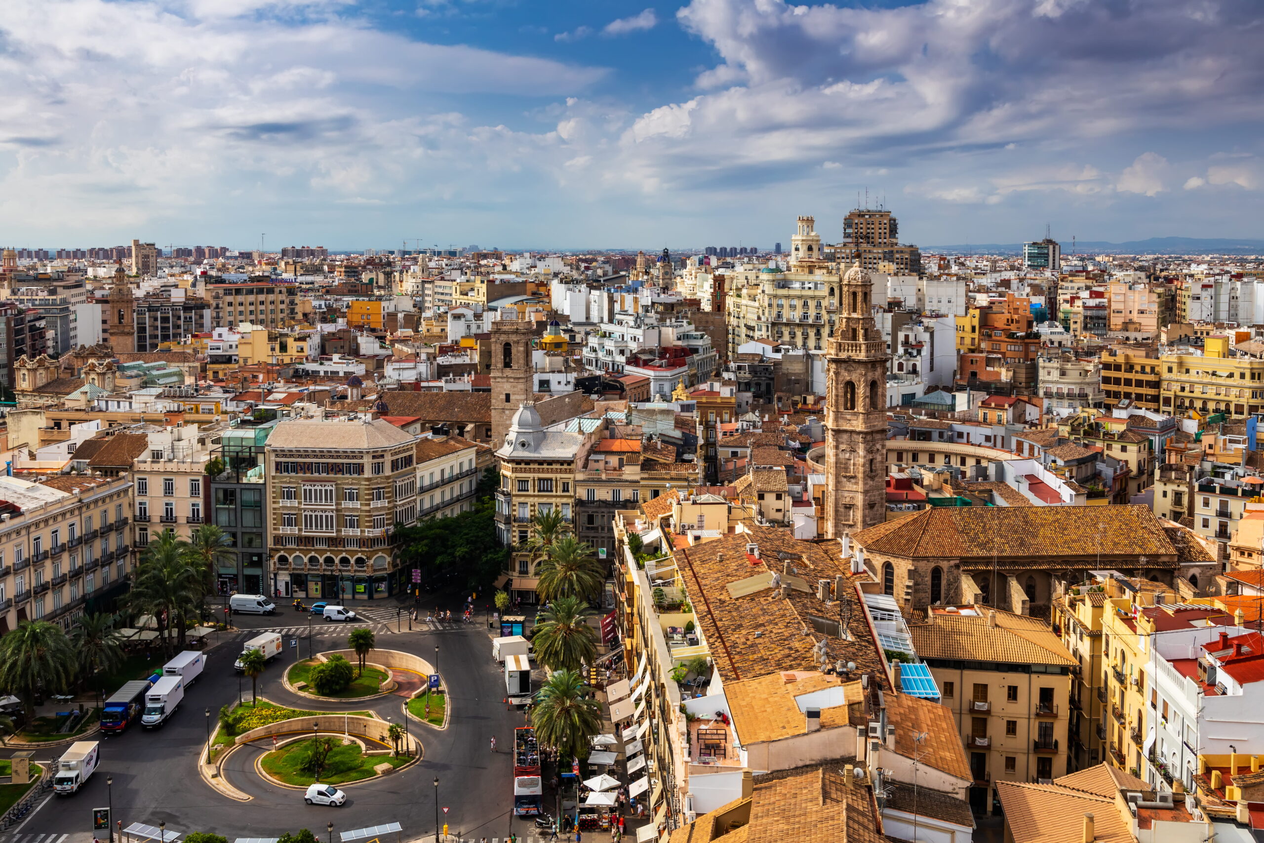 Vue panoramique de Valence avec la Torre del Micalet et les toits du centre historique sous un ciel partiellement nuageux.