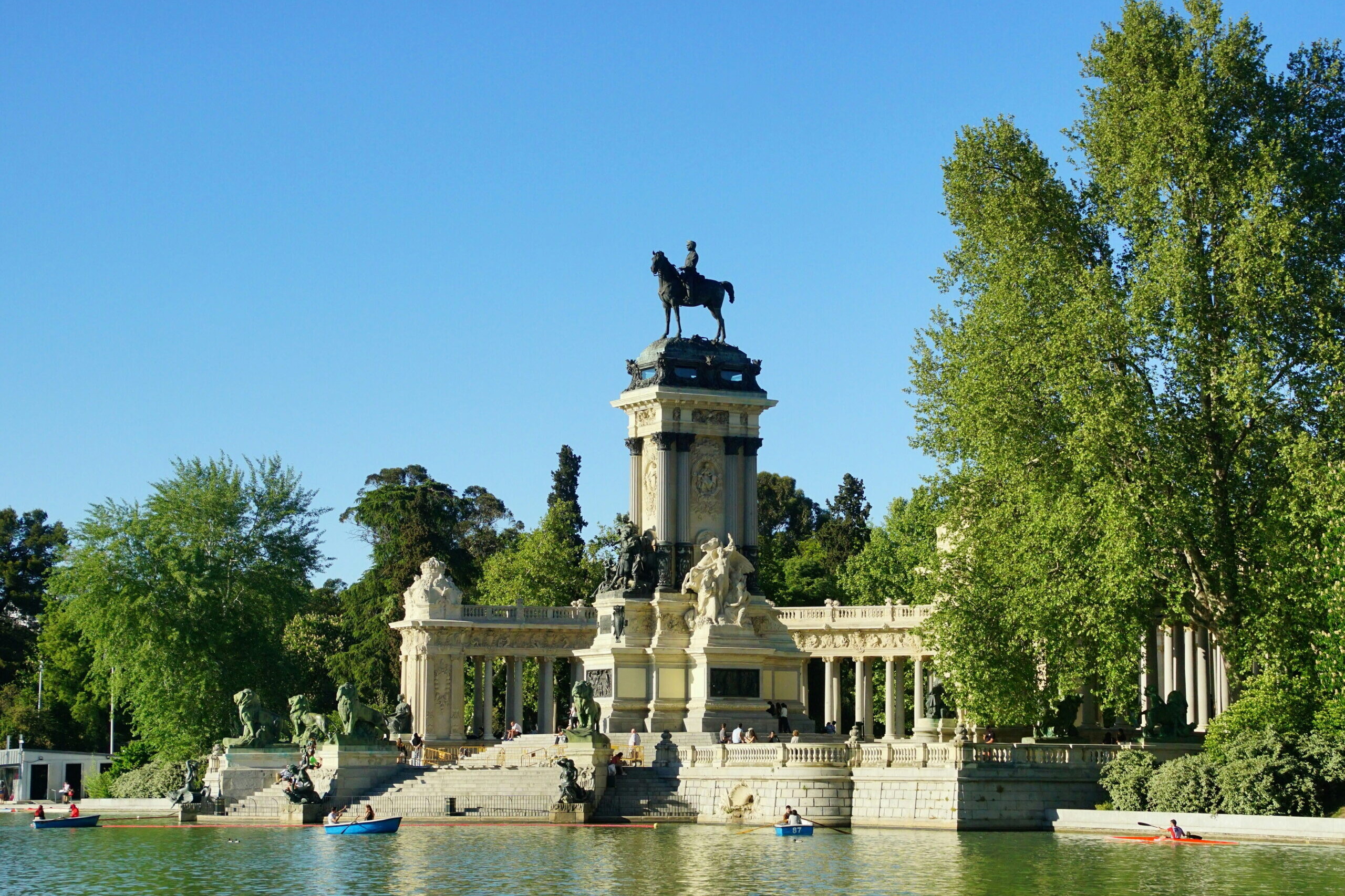 Monument à Alphonse XII au parc du Retiro à Madrid, statue équestre dominant un bassin entouré de colonnades et d’arbres.