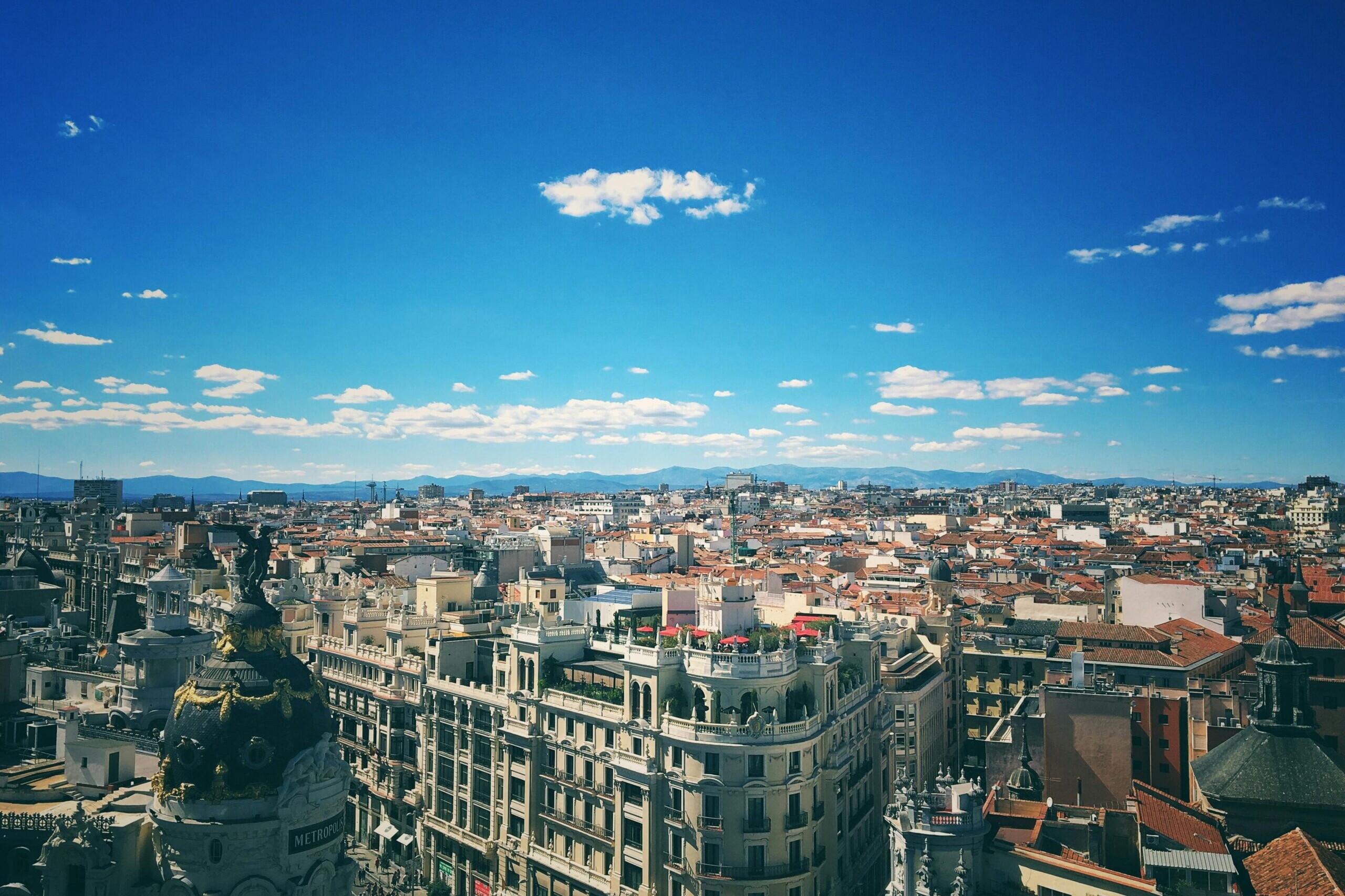 Vue panoramique de Madrid avec ses toits historiques et immeubles embl&eacute;matiques sous un ciel bleu d&eacute;gag&eacute;.