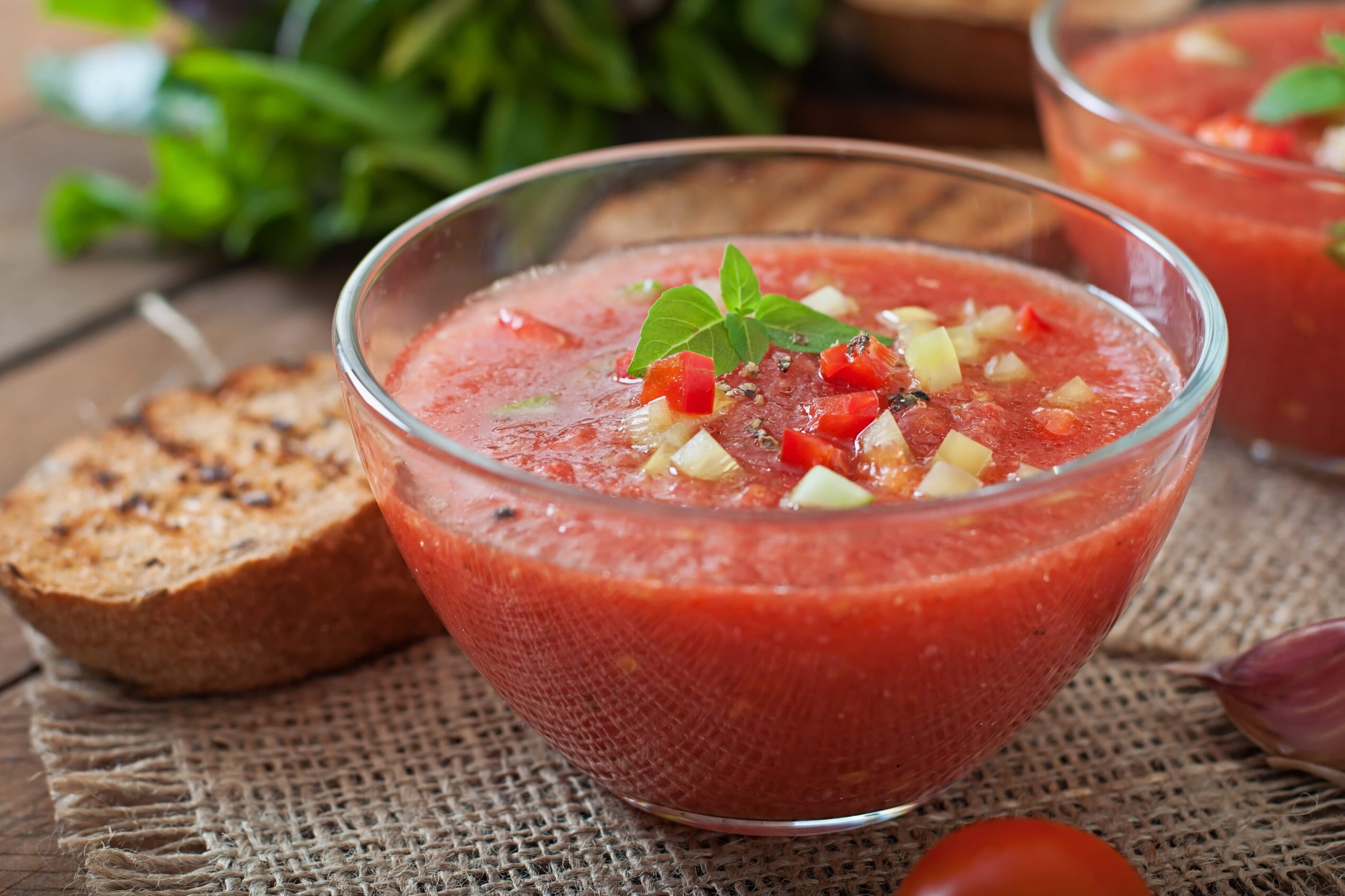 Bol de gazpacho andalou à base de tomates servi avec légumes et pain, spécialité culinaire populaire à Séville.