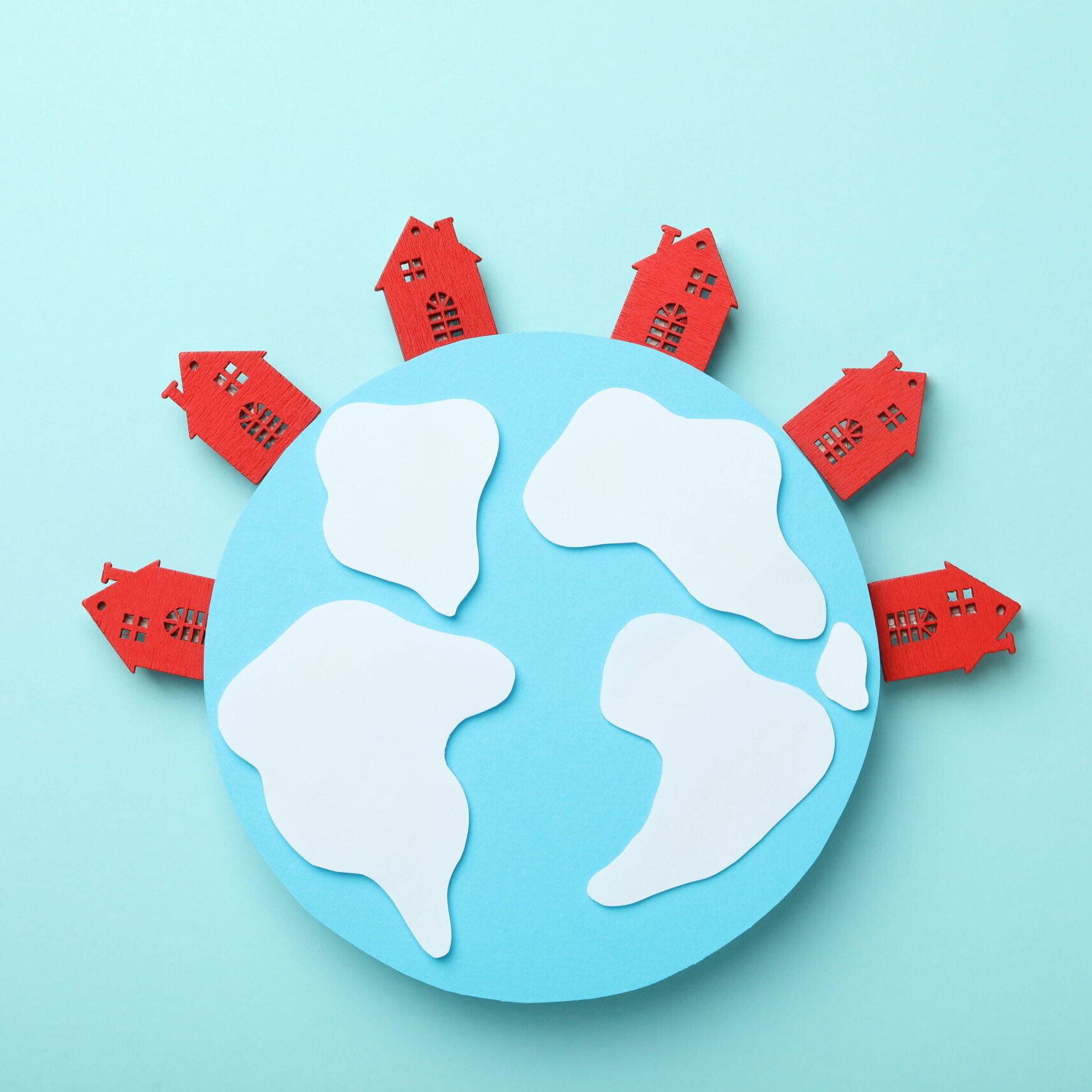 Illustration d’une planète entourée de maisons rouges symbolisant le home exchange et le voyage durable