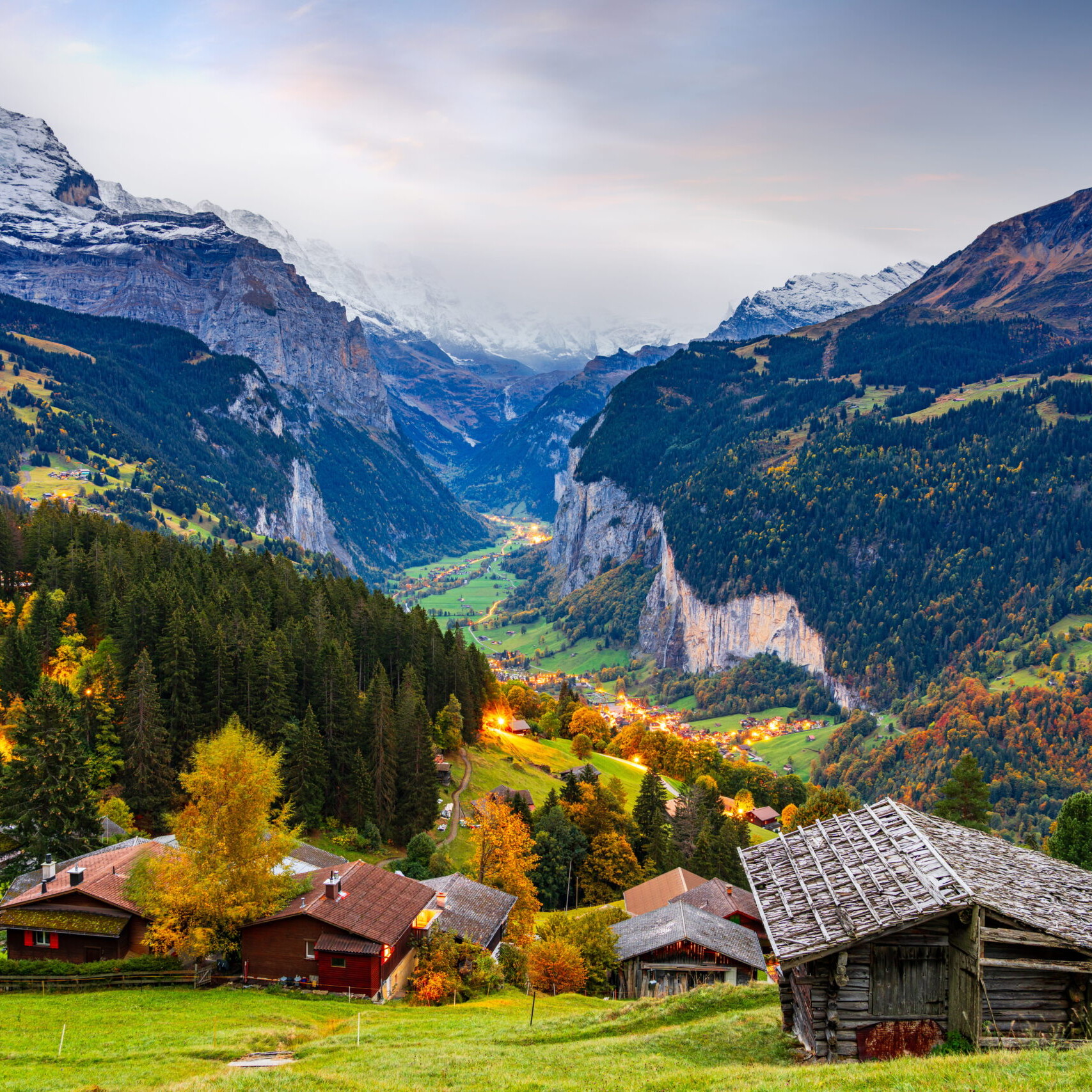 Paysage de la vallée de Lauterbrunnen en Suisse avec montagnes alpines, chalets en bois et forêt en automne