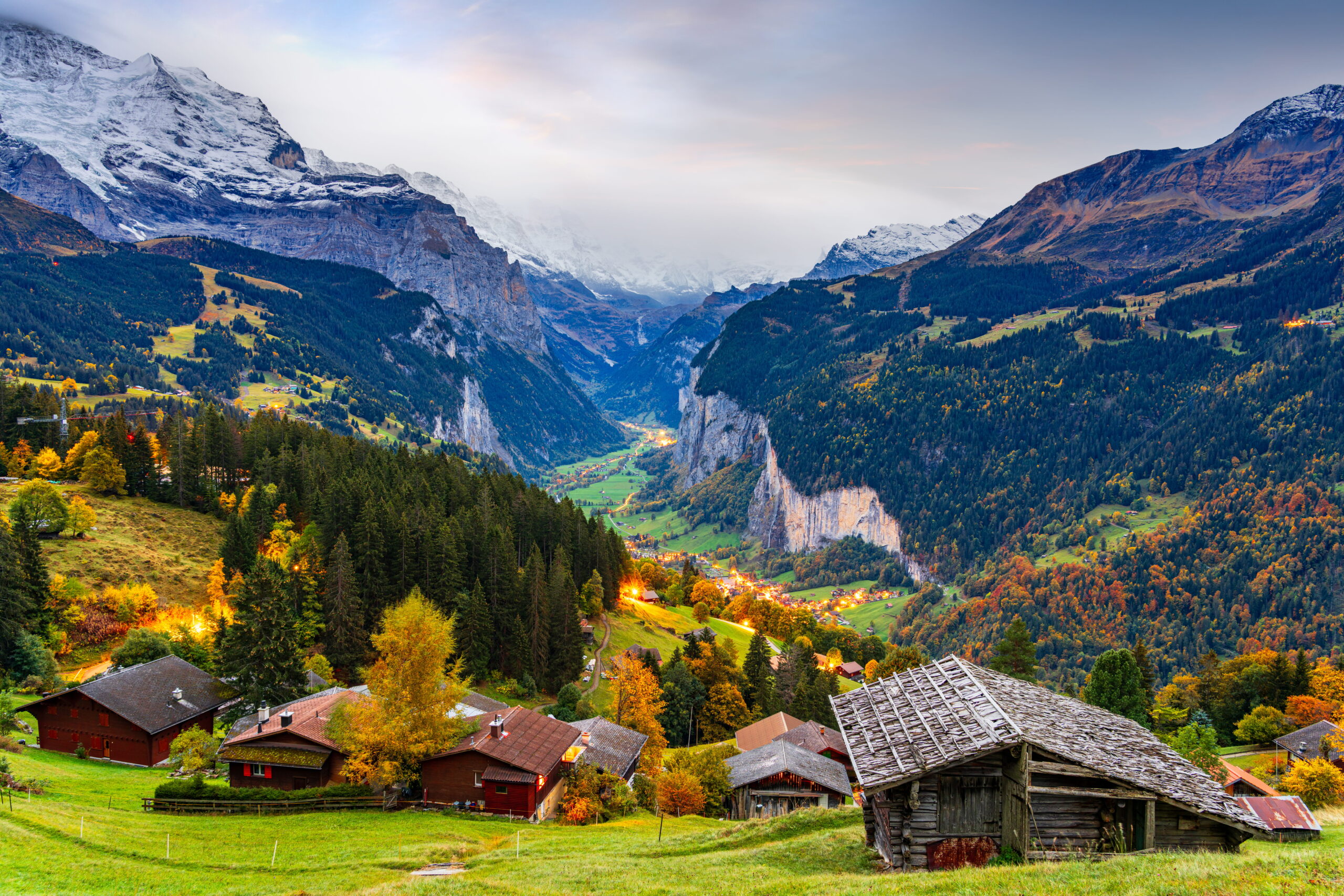 Paysage de la vallée de Lauterbrunnen en Suisse avec montagnes alpines, chalets en bois et forêt en automne