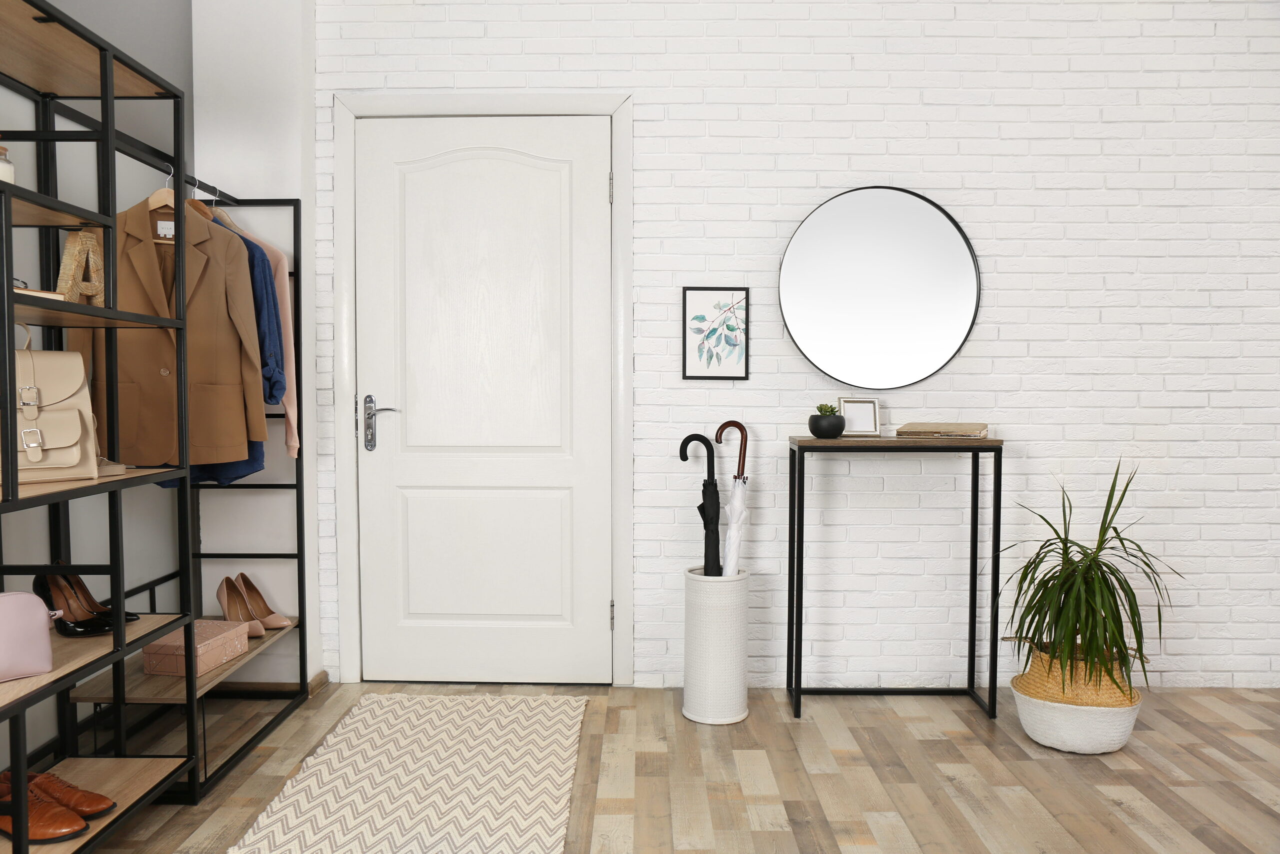 Entrée lumineuse avec étagères de rangement, porte-manteaux, chaussures et décoration minimaliste moderne.