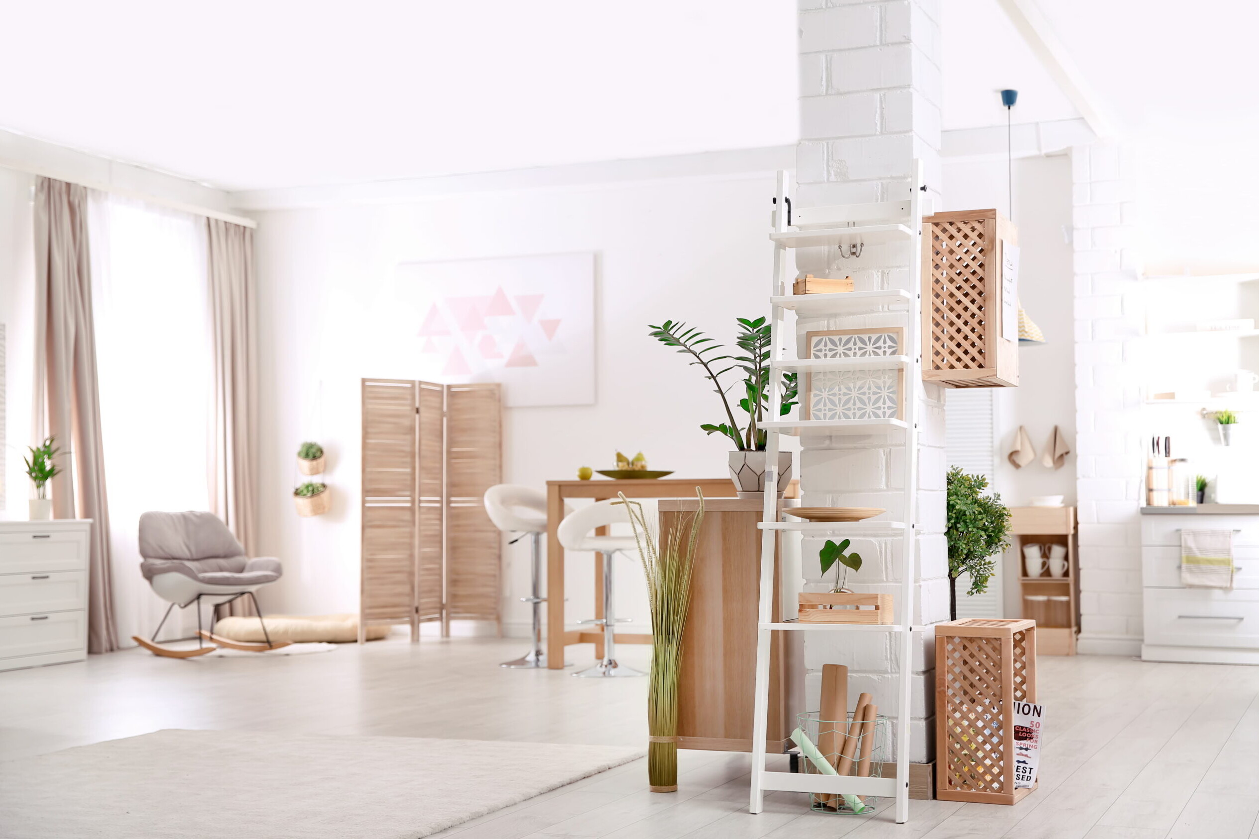 Pièce lumineuse avec étagère échelle, paniers de rangement et décoration minimaliste dans un intérieur moderne.
