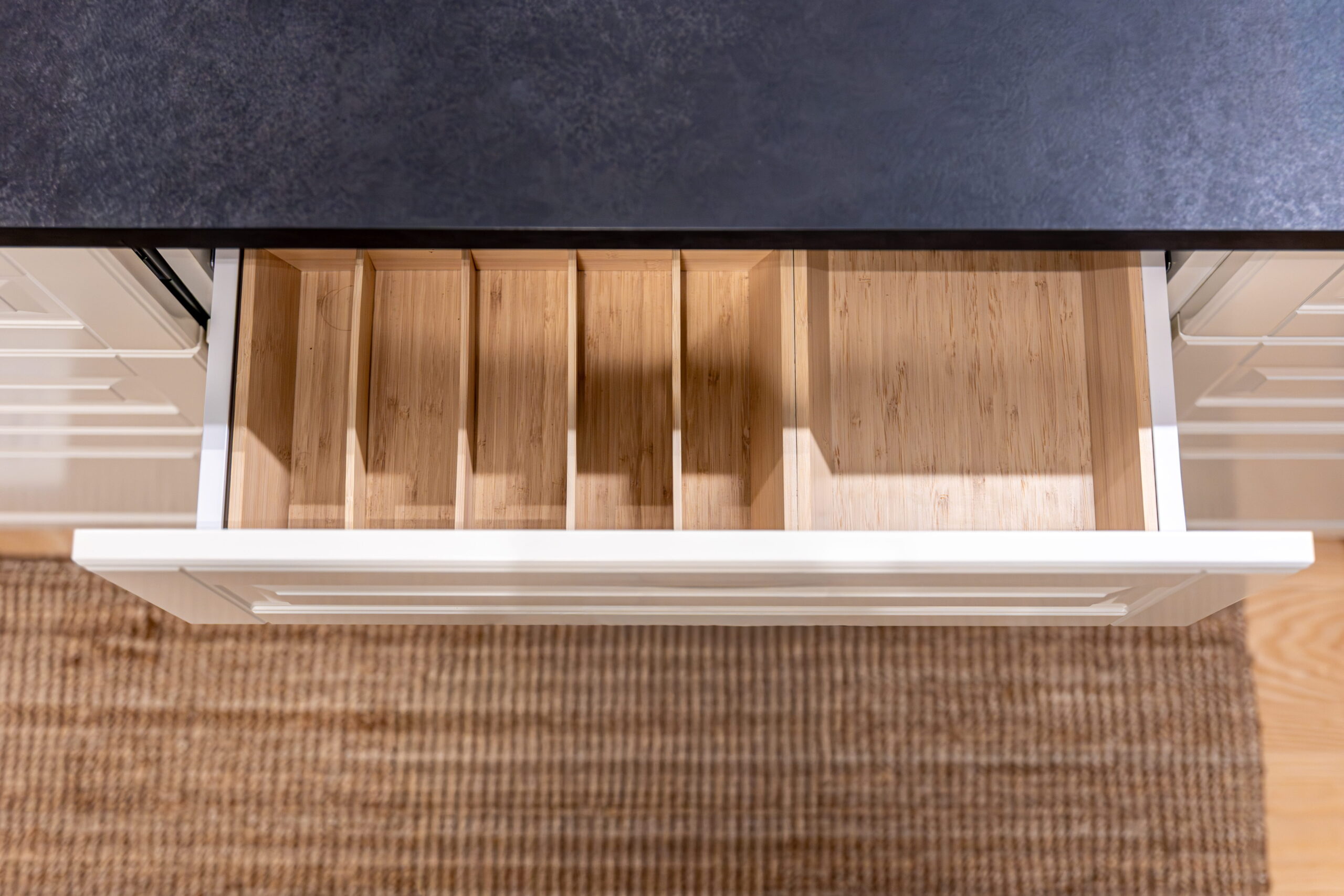 Tiroir de cuisine en bois avec compartiments de rangement intégrés pour organiser les couverts et accessoires.