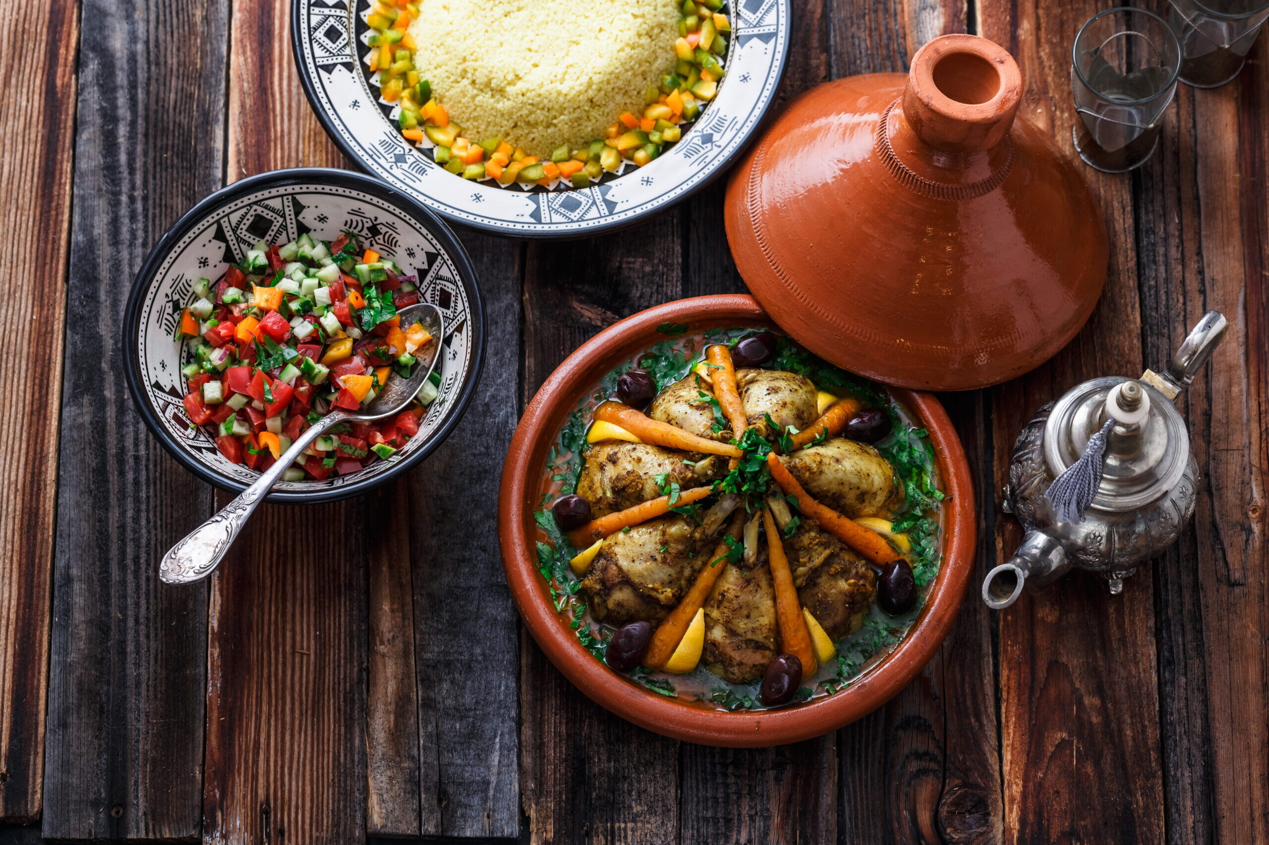 Table marocaine avec tajine de poulet, couscous, salade fraîche et thé à la menthe
