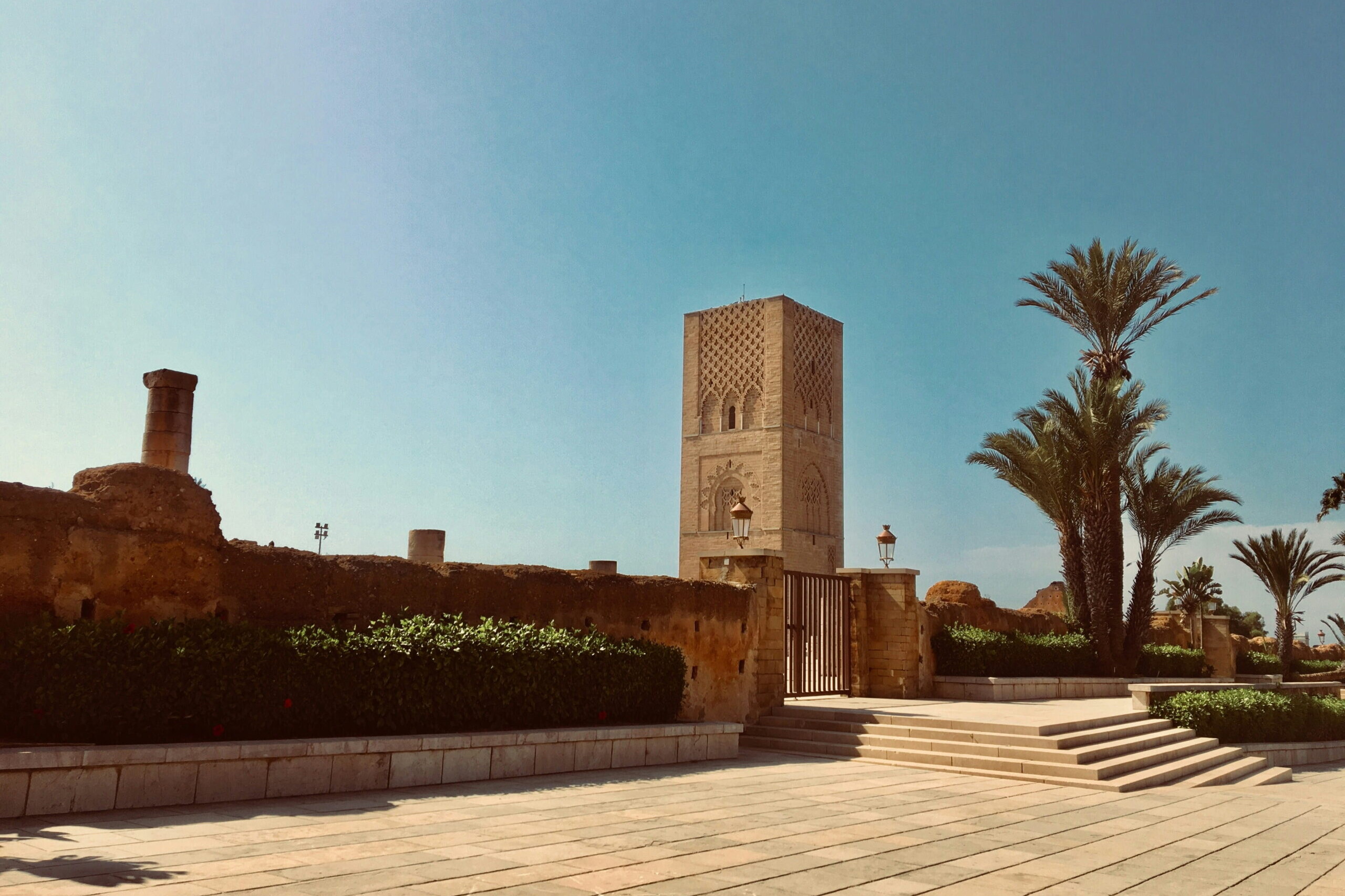 Tour Hassan à Rabat avec palmiers et esplanade sous un ciel bleu